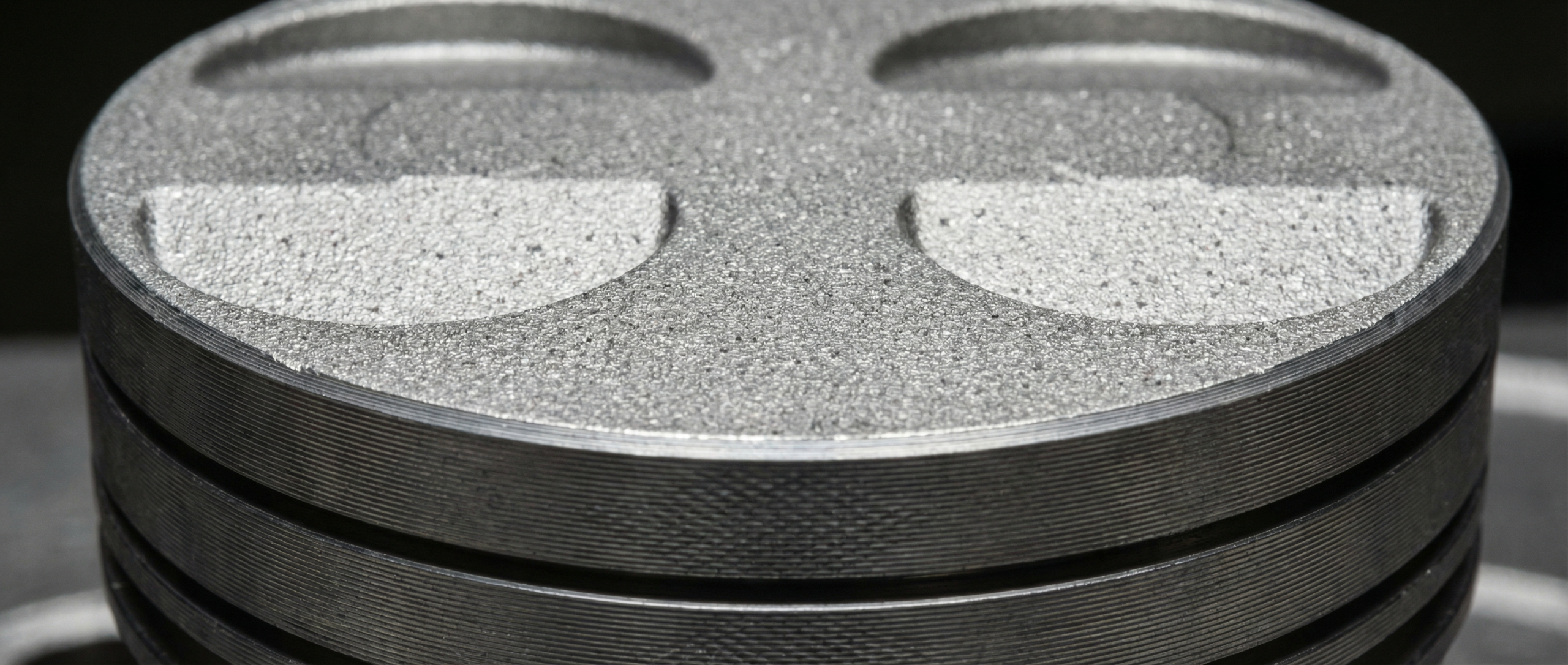 Close-up of a hypereutectic piston
– Detailed macro shot showing the piston crown and skirt surface texture.